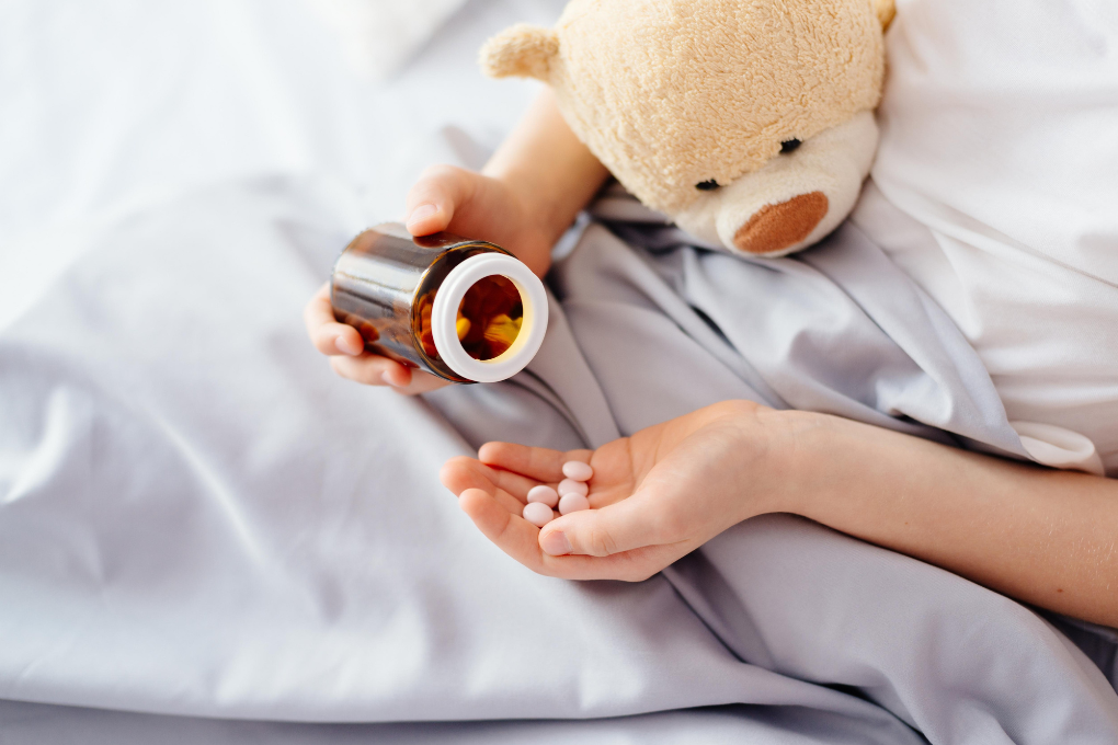 A child with antibiotics in bed
